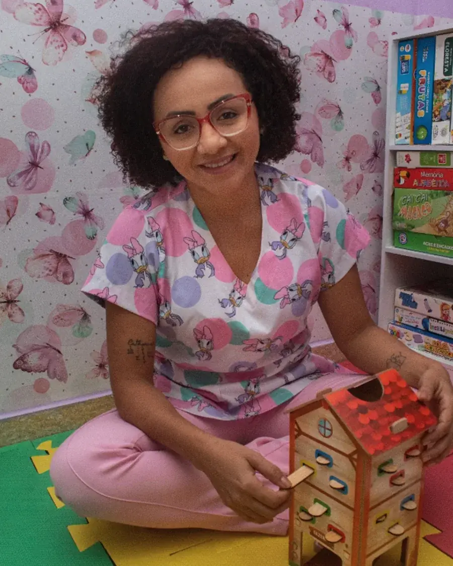 Rafisa Almeida na sala de terapia infantil, com jogos e brinquedos usados nos atendimentos